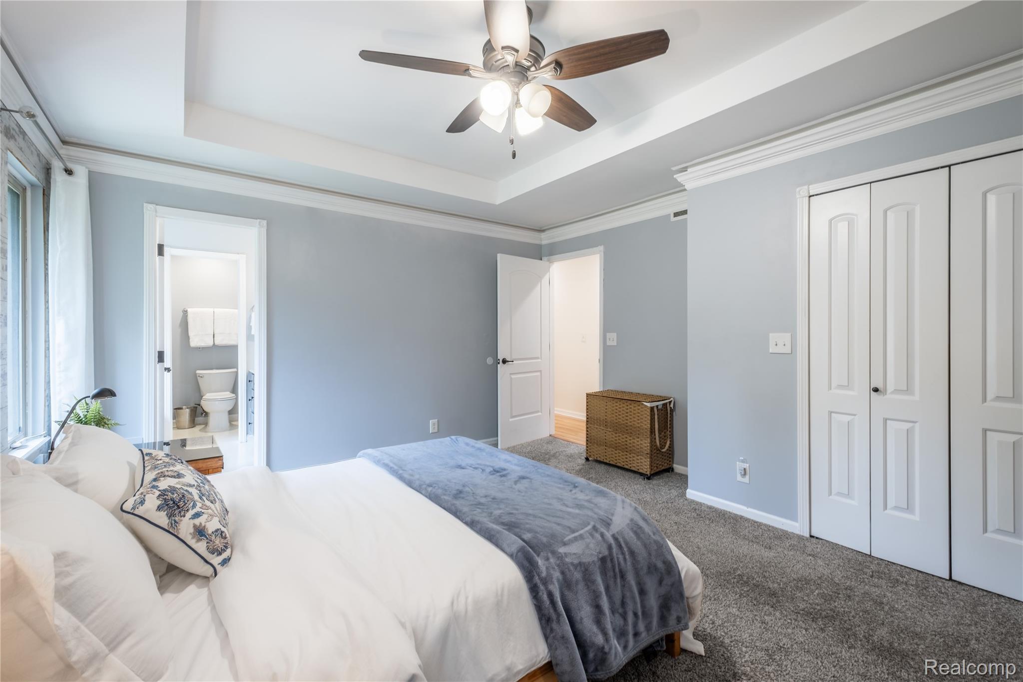 Recessed ceiling with an overhead fan featuring wood-finish blades and integrated lighting