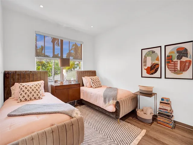 a bedroom with two beds and painting on the wall