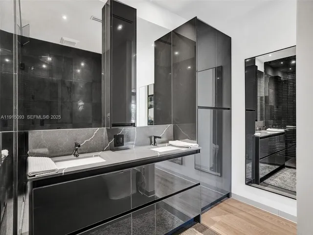 a bathroom with a sink a light fixture and a glass door