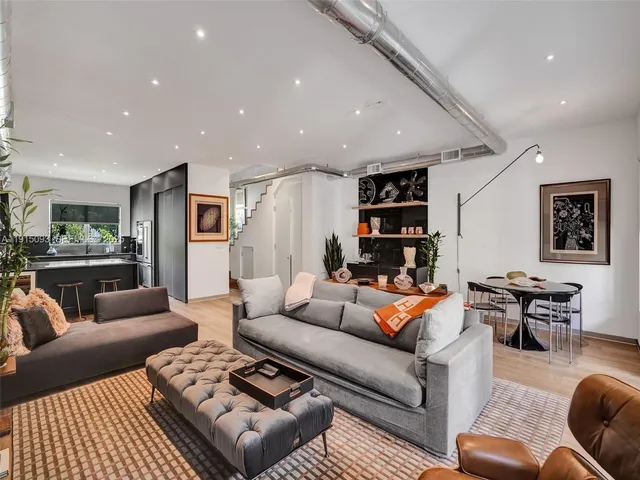 a living room with furniture kitchen view and a table