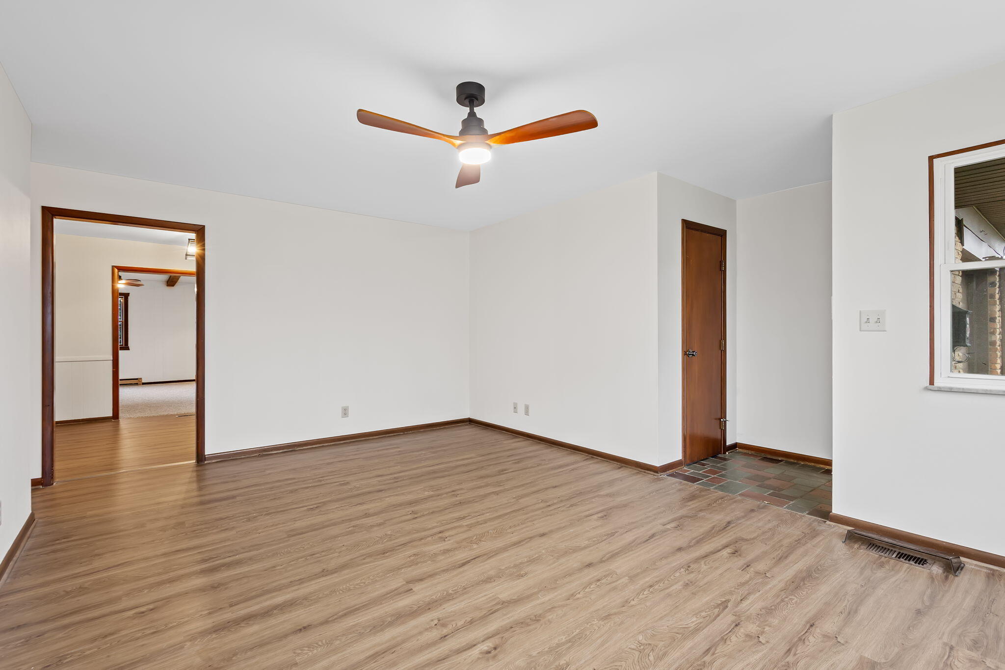 708 East Maple Street Rensselaer, IN 47978 - Photo 7 of 33 a view of an empty room with wooden floor and a ceiling fan