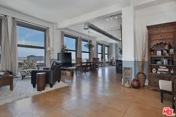 a living room with furniture large window and flat screen tv