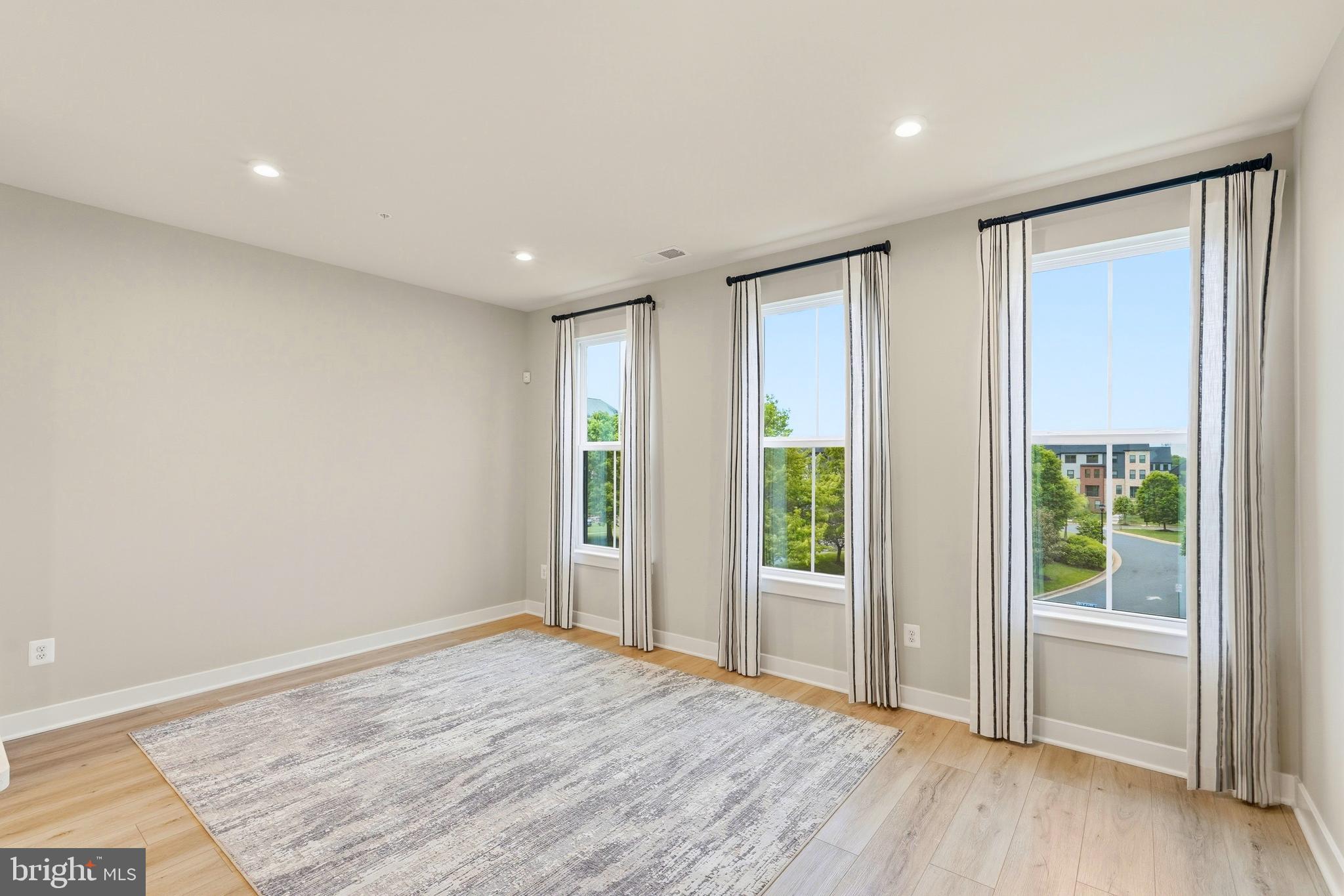 14538 George Carter Way, Unit 287 Chantilly, VA 20151 - Photo 19 of 87 an empty room with wooden floor and windows