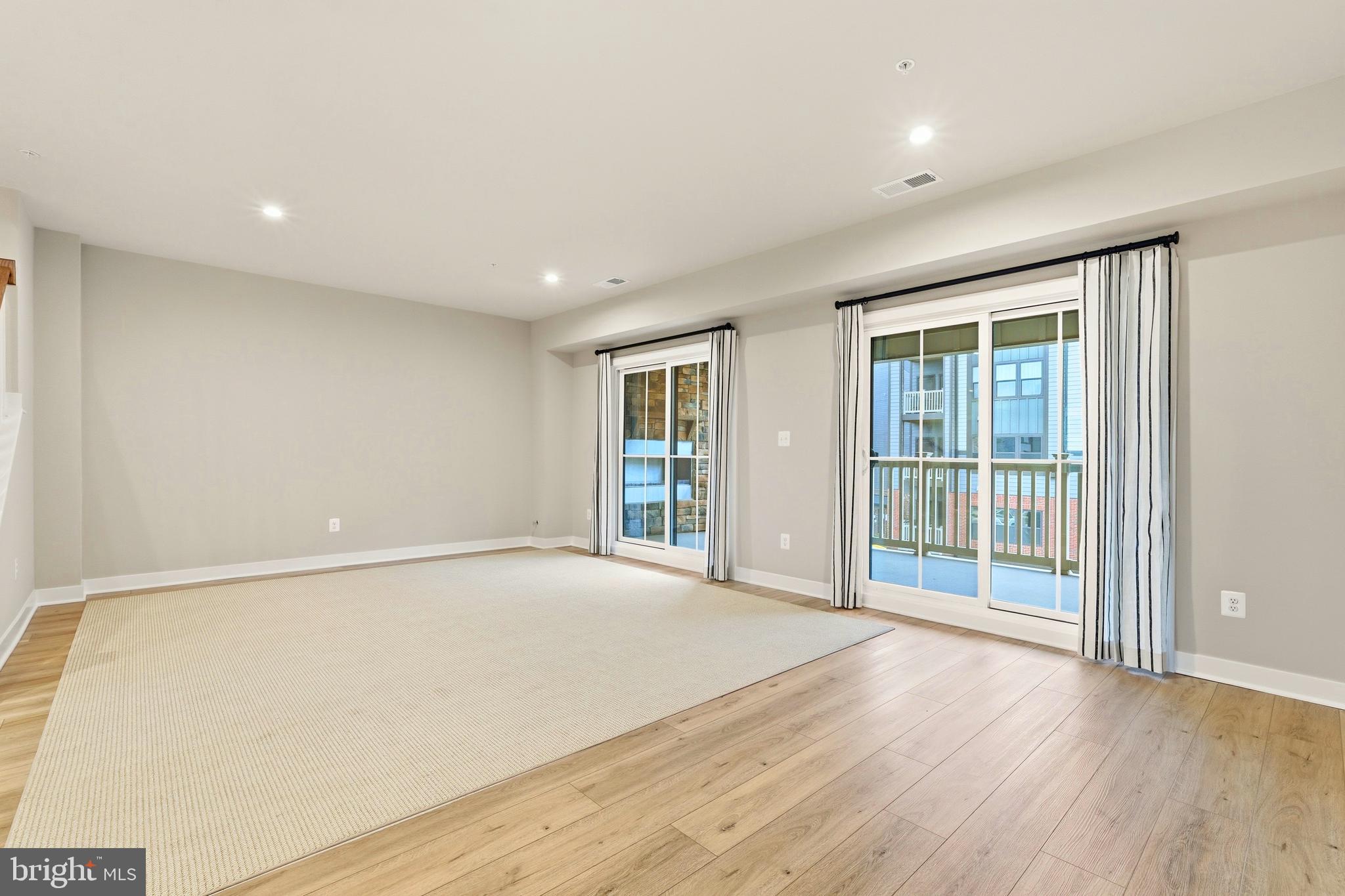 14538 George Carter Way, Unit 287 Chantilly, VA 20151 - Photo 25 of 87 a view of an empty room with wooden floor and a window
