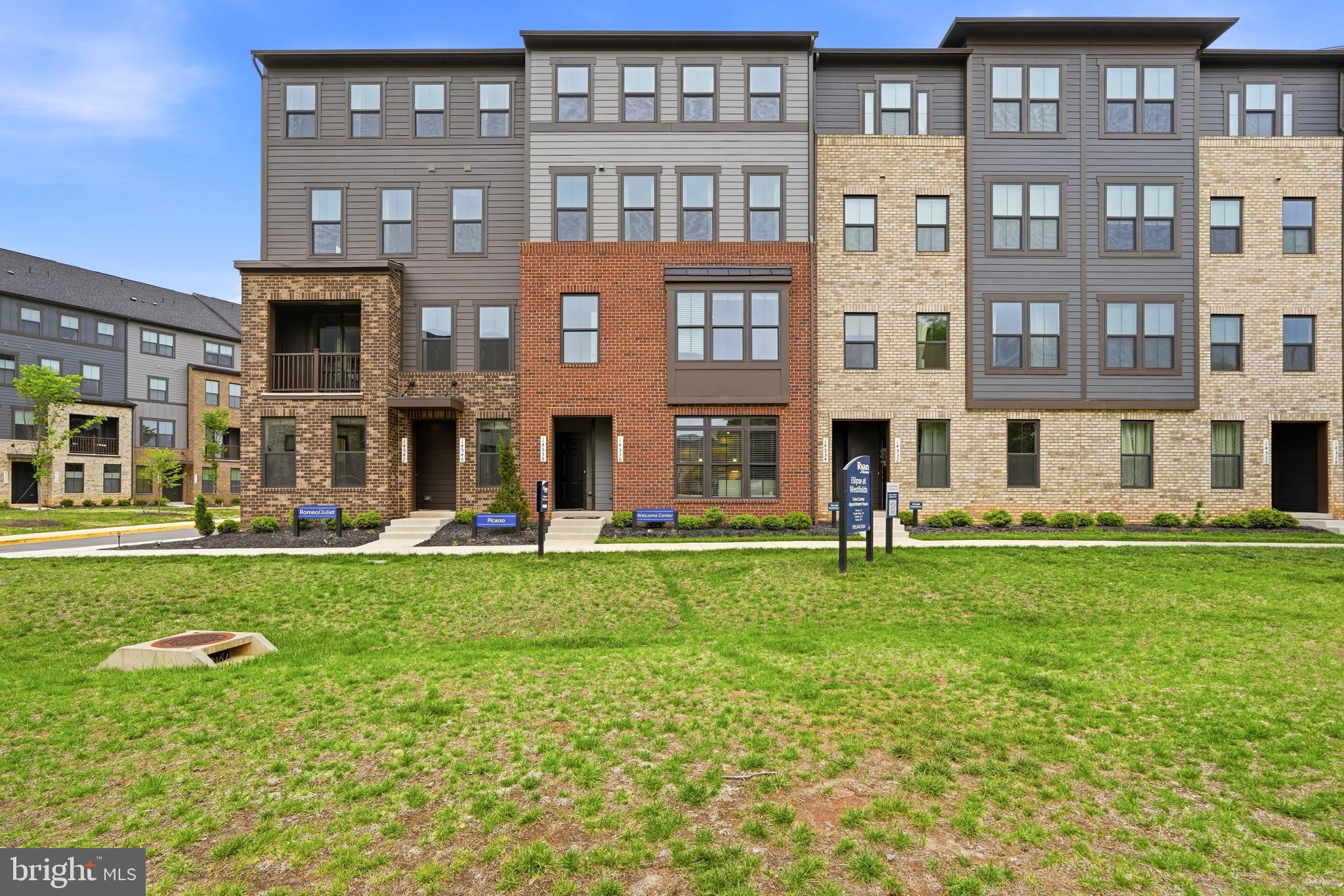14538 George Carter Way, Unit 287 Chantilly, VA 20151 - Photo 3 of 87 a front view of a residential apartment building with a yard
