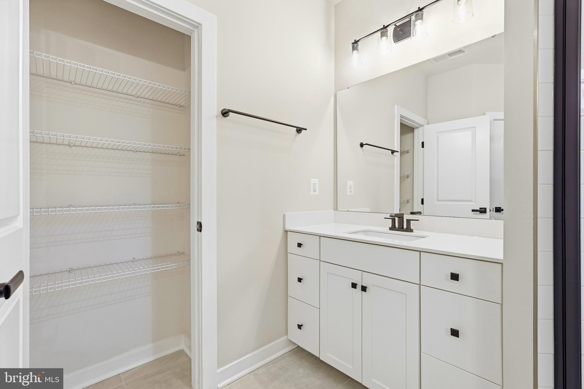 14538 George Carter Way, Unit 287 Chantilly, VA 20151 - Photo 44 of 87 a bathroom with a double vanity sink a mirror and a shower