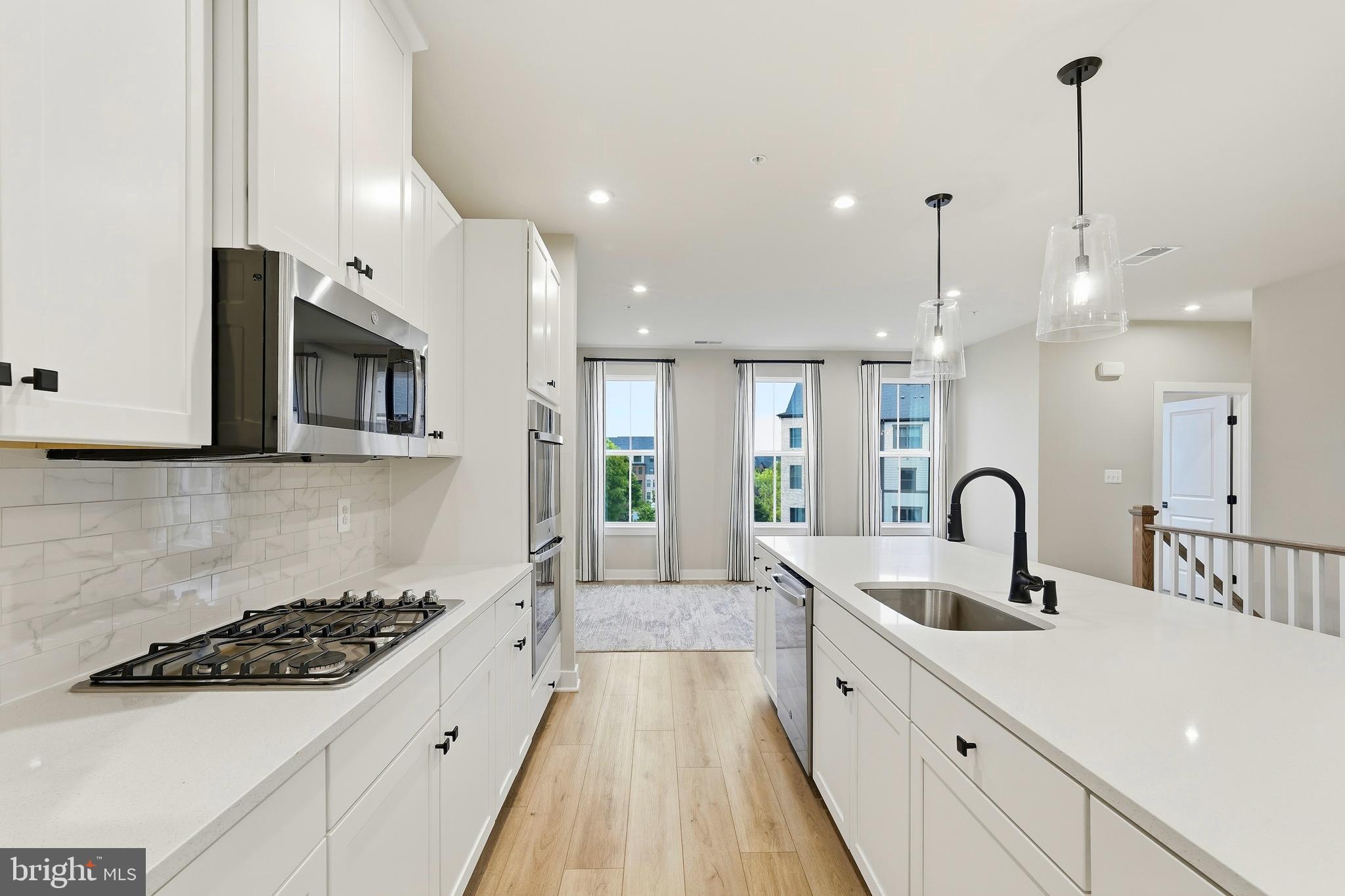 14538 George Carter Way, Unit 287 Chantilly, VA 20151 - Photo 7 of 87 a kitchen with stainless steel appliances granite countertop a sink a stove and a wooden floors