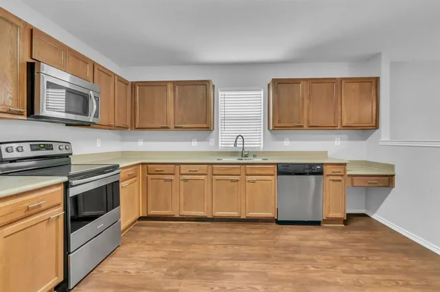 a kitchen with granite countertop a sink stove and cabinets