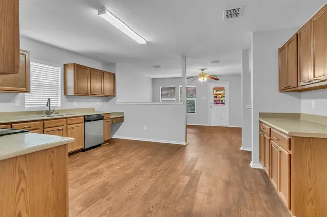 a kitchen with kitchen island granite countertop wooden floors and stainless steel appliances