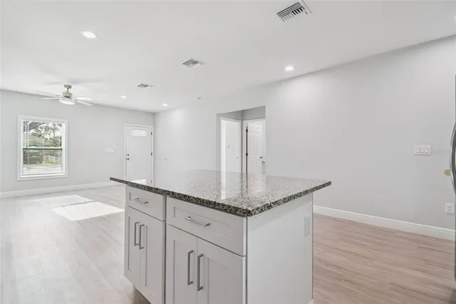 a hallway with white cabinets and wooden floor