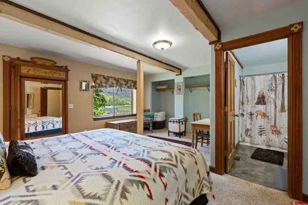 a spacious bedroom with a bed couch and a dresser