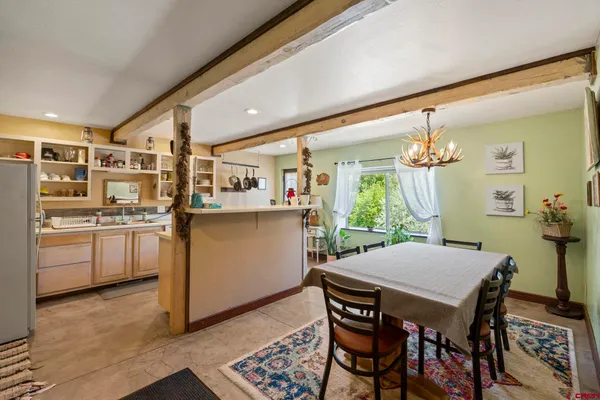 a kitchen with a table chairs refrigerator and cabinets