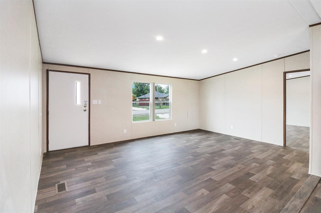 708 West 8th Street Coleman, TX 76834 - Photo 4 of 25 a view of an empty room with wooden floor and a window