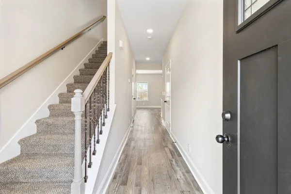 a view of a hallway with wooden floor and staircase