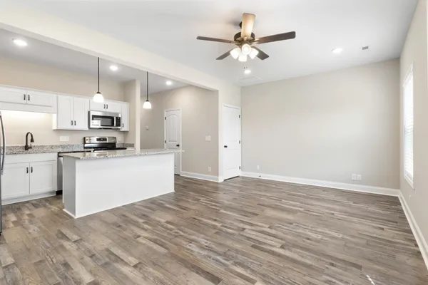 a view of kitchen with granite countertop cabinets and refrigerator