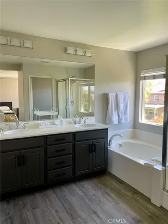 a spacious bathroom with a tub double sink large mirror and