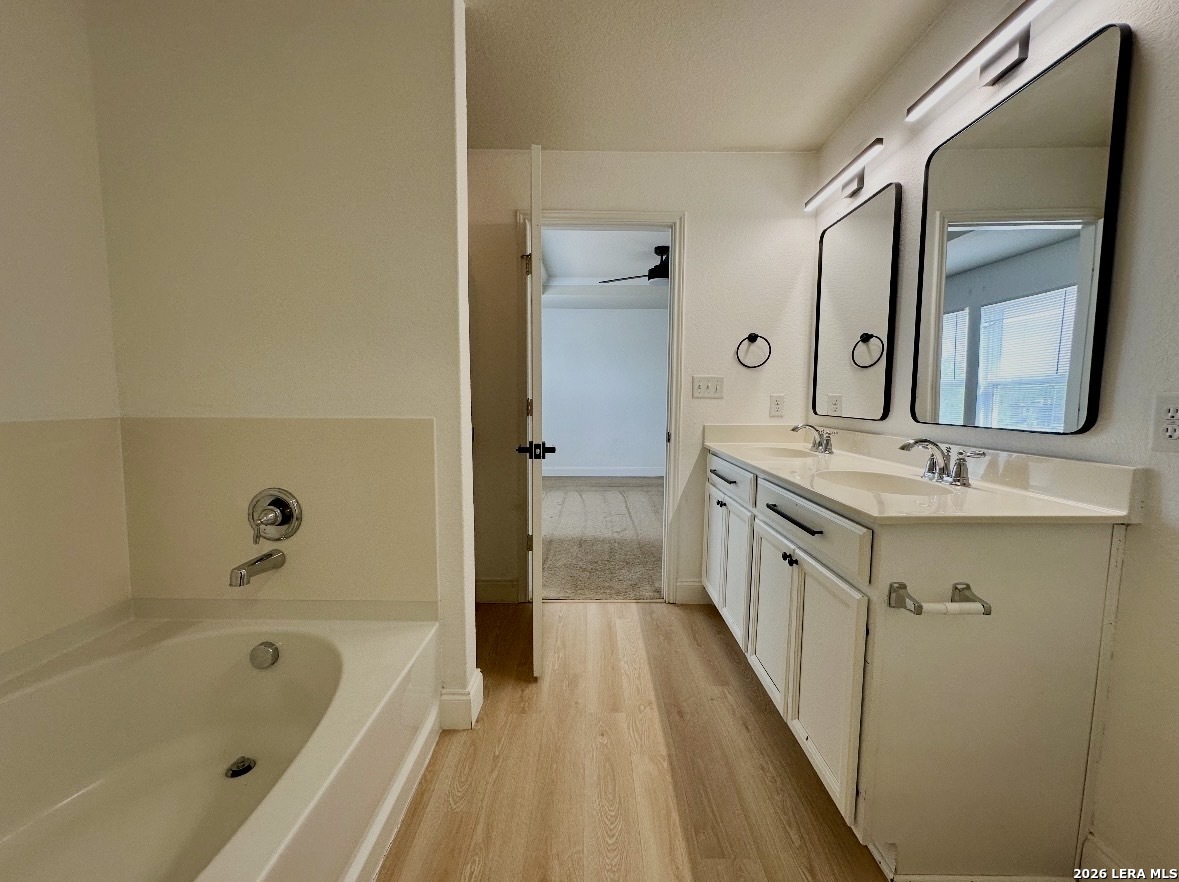 443 Harvest Point Schertz, TX 78154 - Photo 13 of 13 a bathroom with a double vanity sink a mirror and a bathtub