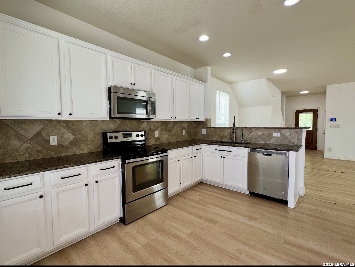 443 Harvest Point Schertz, TX 78154 - Photo 4 of 13 a kitchen with granite countertop white cabinets and stainless steel appliances