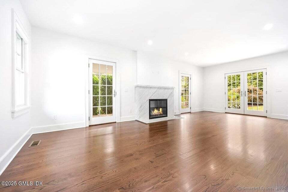 2 Sound View Terrace Greenwich, CT 06830 - Photo 13 of 39 an empty room with wooden floor fireplace and windows