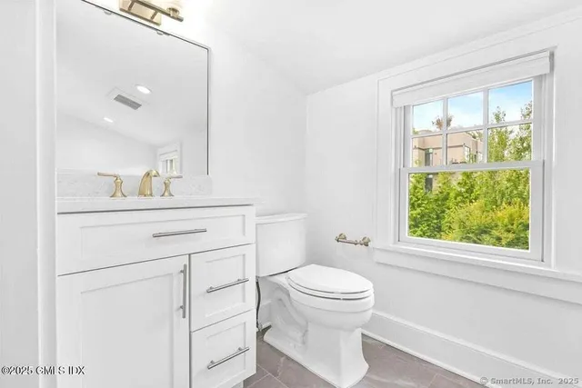 a bathroom with a sink a toilet and a window