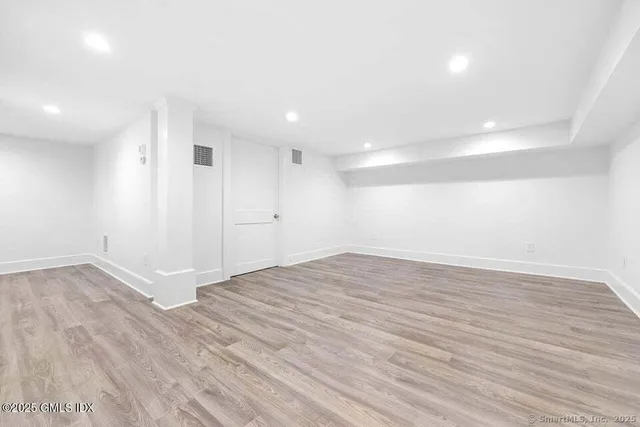 a view of empty room with wooden floor
