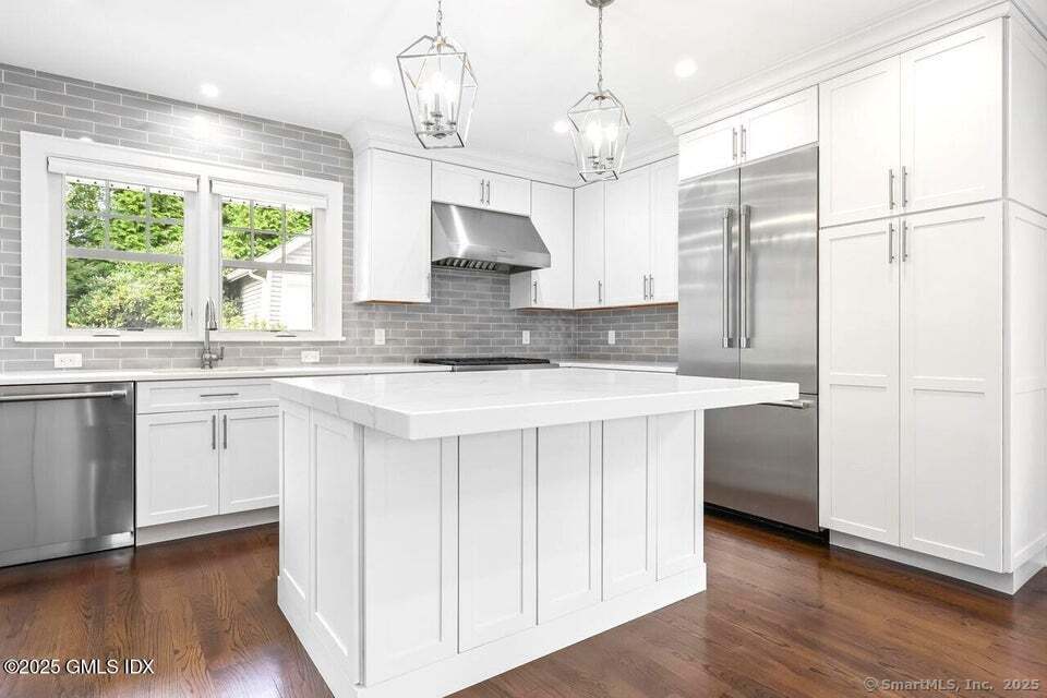 2 Sound View Terrace Greenwich, CT 06830 - Photo 4 of 39 a kitchen with kitchen island granite countertop a stove a sink a center island a refrigerator and a wooden floor