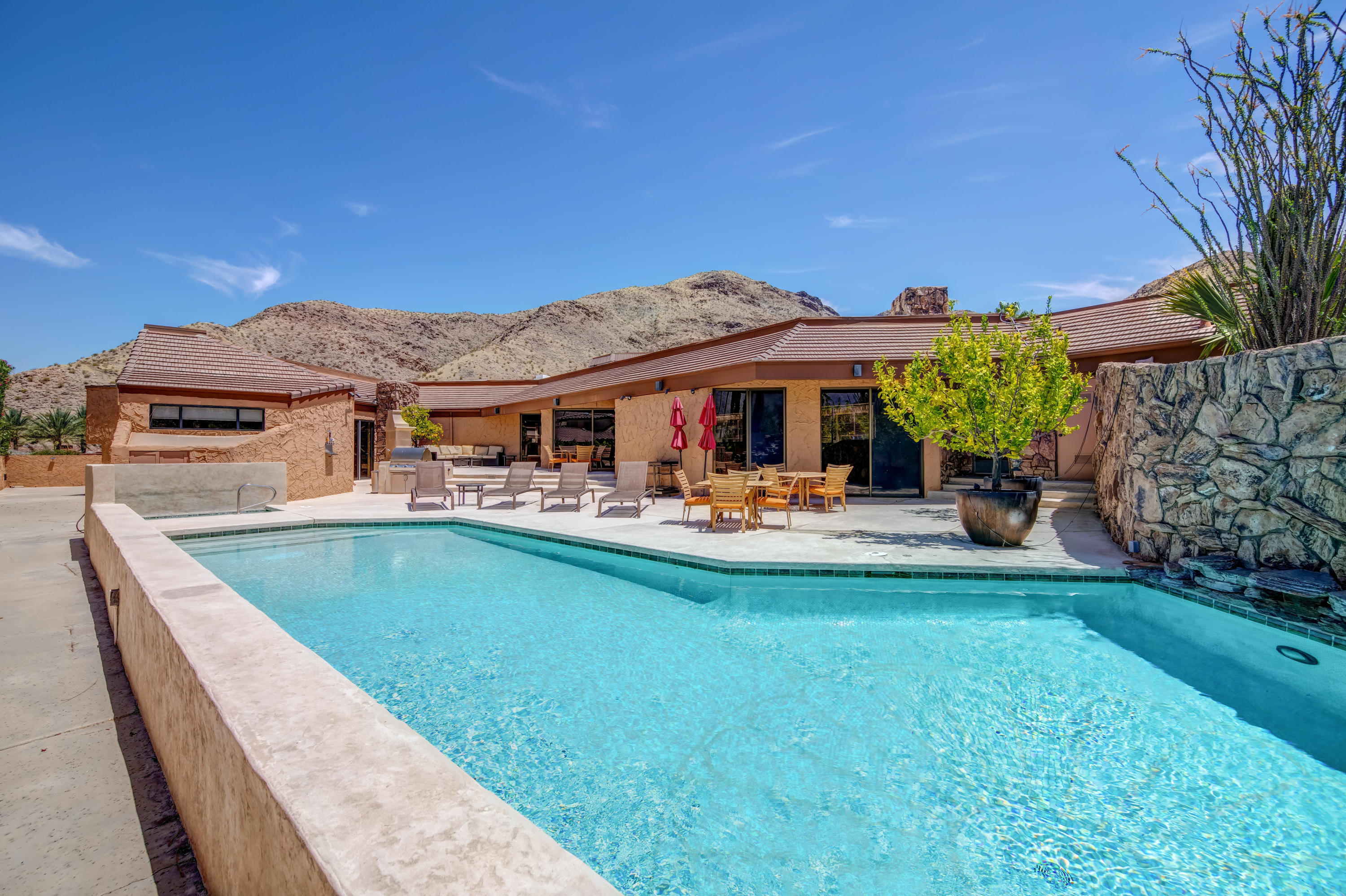 1650 Ridgemore Drive Palm Springs, CA 92264 - Photo 2 of 69 a view of swimming pool with lawn chairs under an umbrella