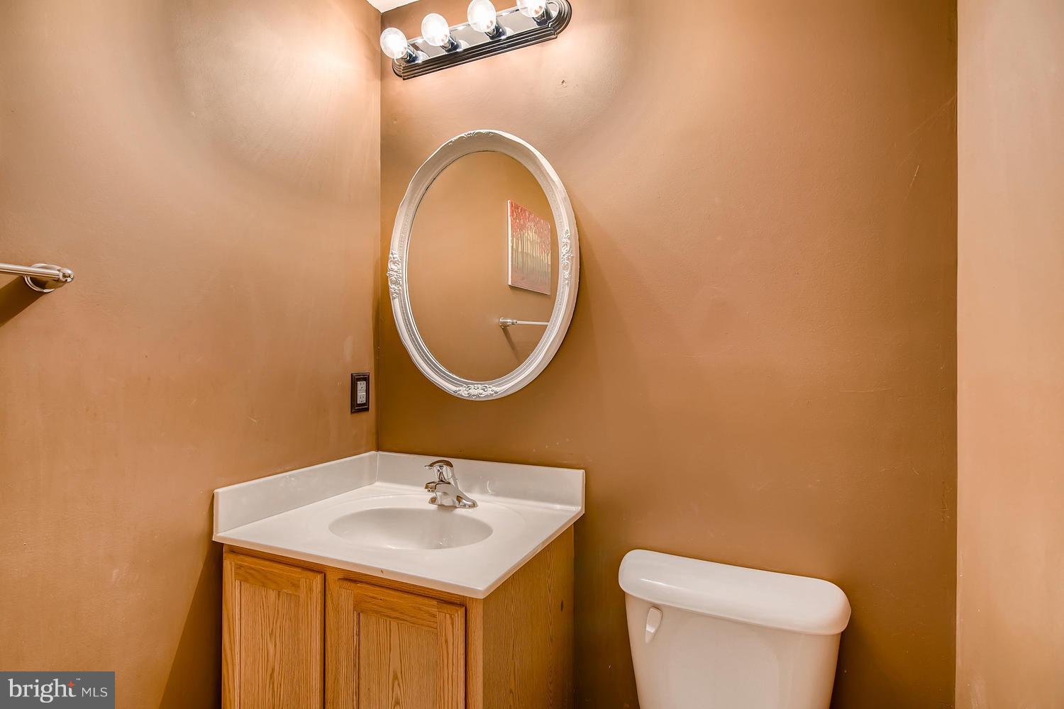 3089 Raking Leaf Drive Abingdon, MD 21009 - Photo 23 of 28 a bathroom with a toilet sink and mirror