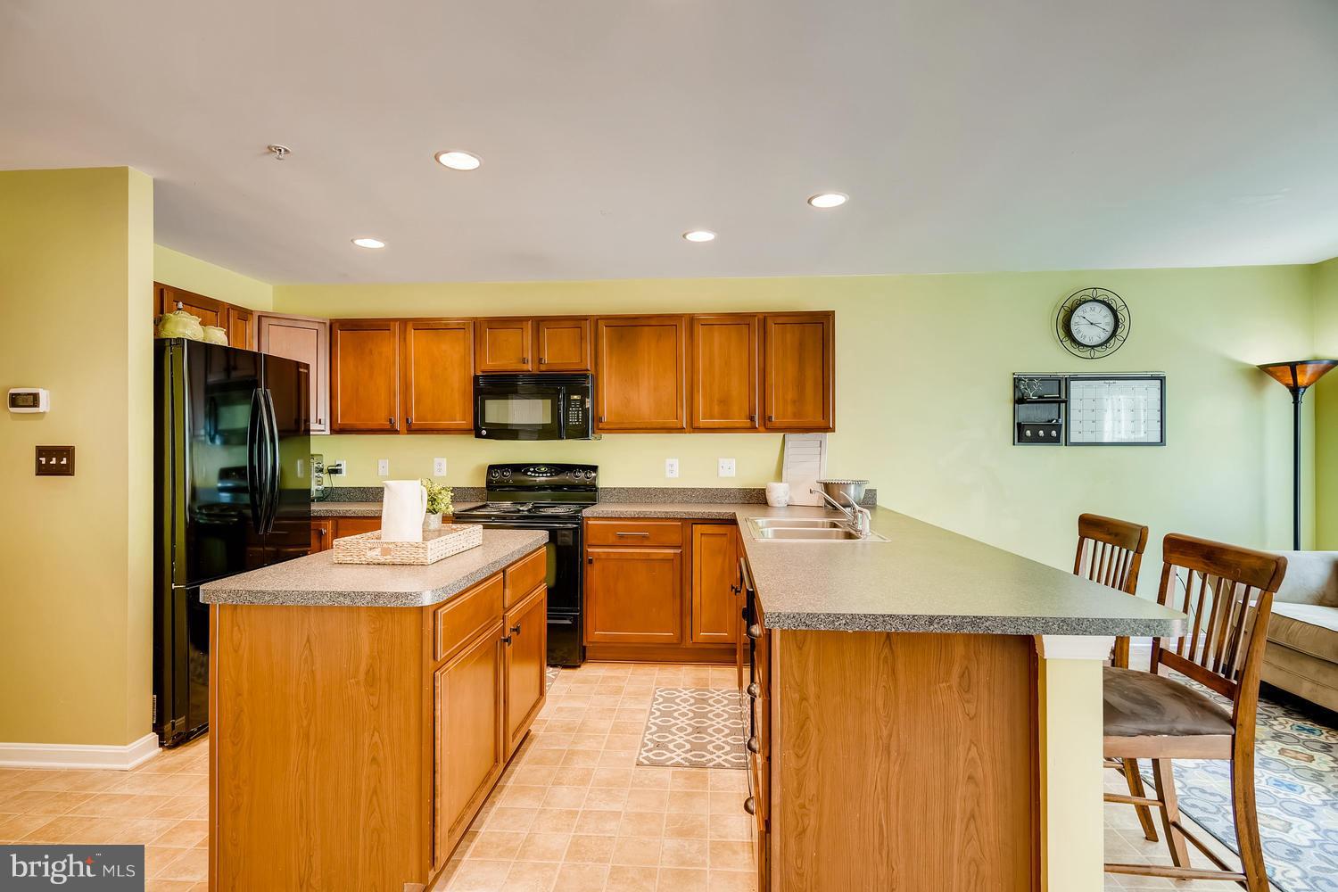 3089 Raking Leaf Drive Abingdon, MD 21009 - Photo 6 of 28 a kitchen with stainless steel appliances granite countertop a sink a stove top oven a refrigerator with island and chairs