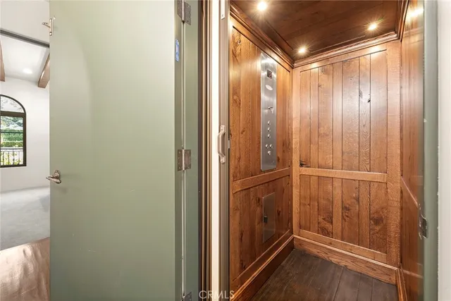 a bedroom with a bed a chair and potted plant on the dresser