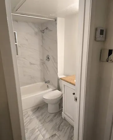 a view of a room with wooden floor and white walls