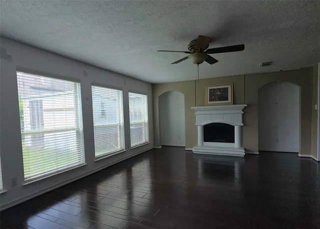 a view of empty room with fireplace and wooden floor