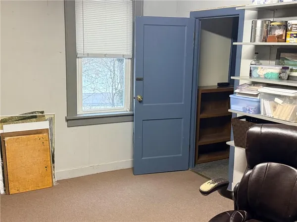 a view of an empty room with workspace and a window