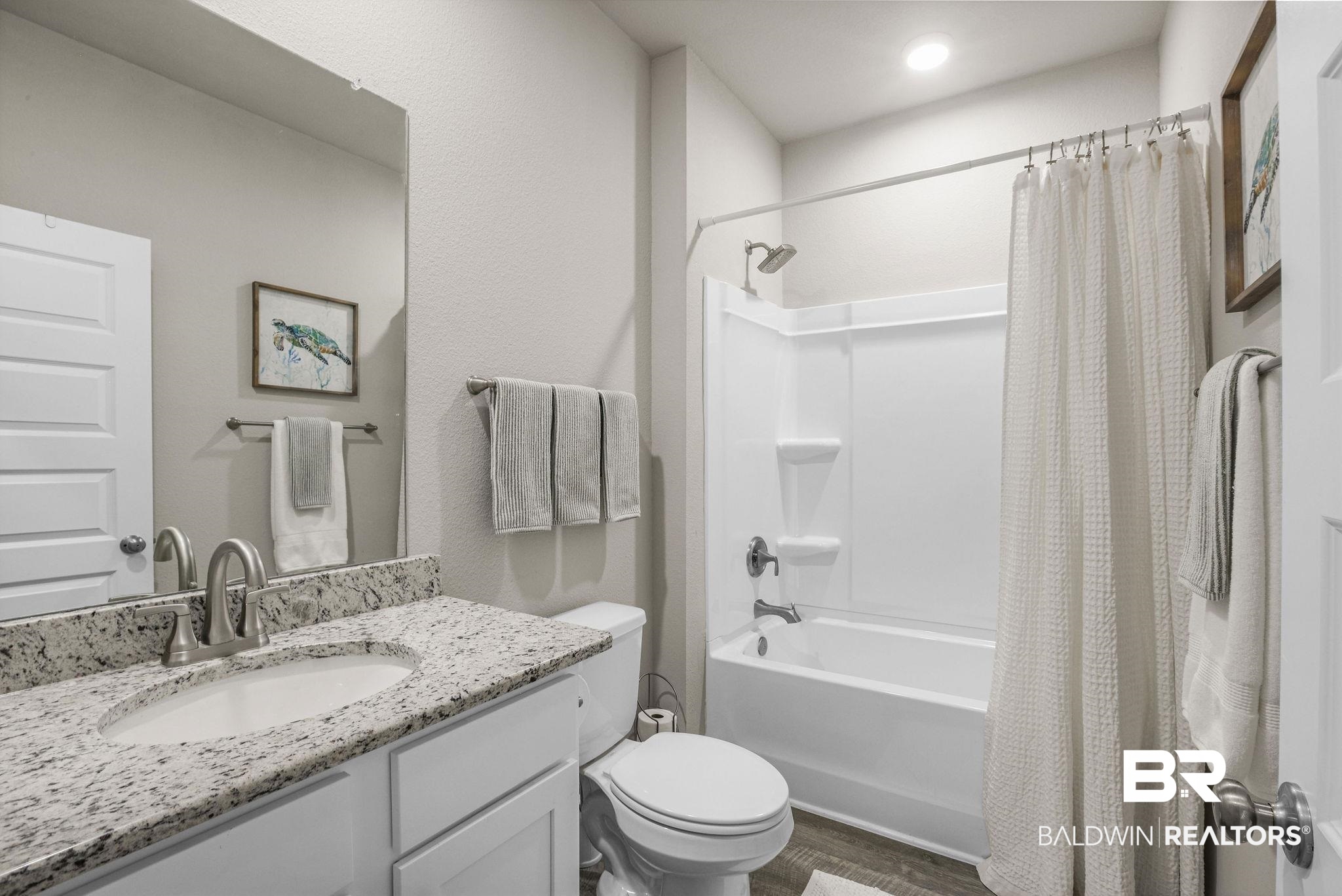 9056 Impala Drive Foley, AL 36535 - Photo 16 of 22 Full bathroom featuring shower / bathtub combination with curtain, vanity, wood-type flooring, and toilet
