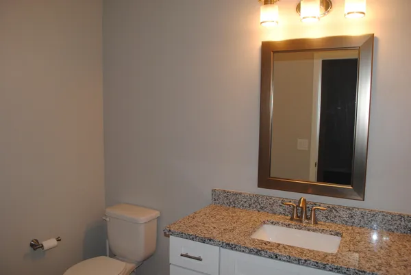 a bathroom with a granite countertop sink and a mirror