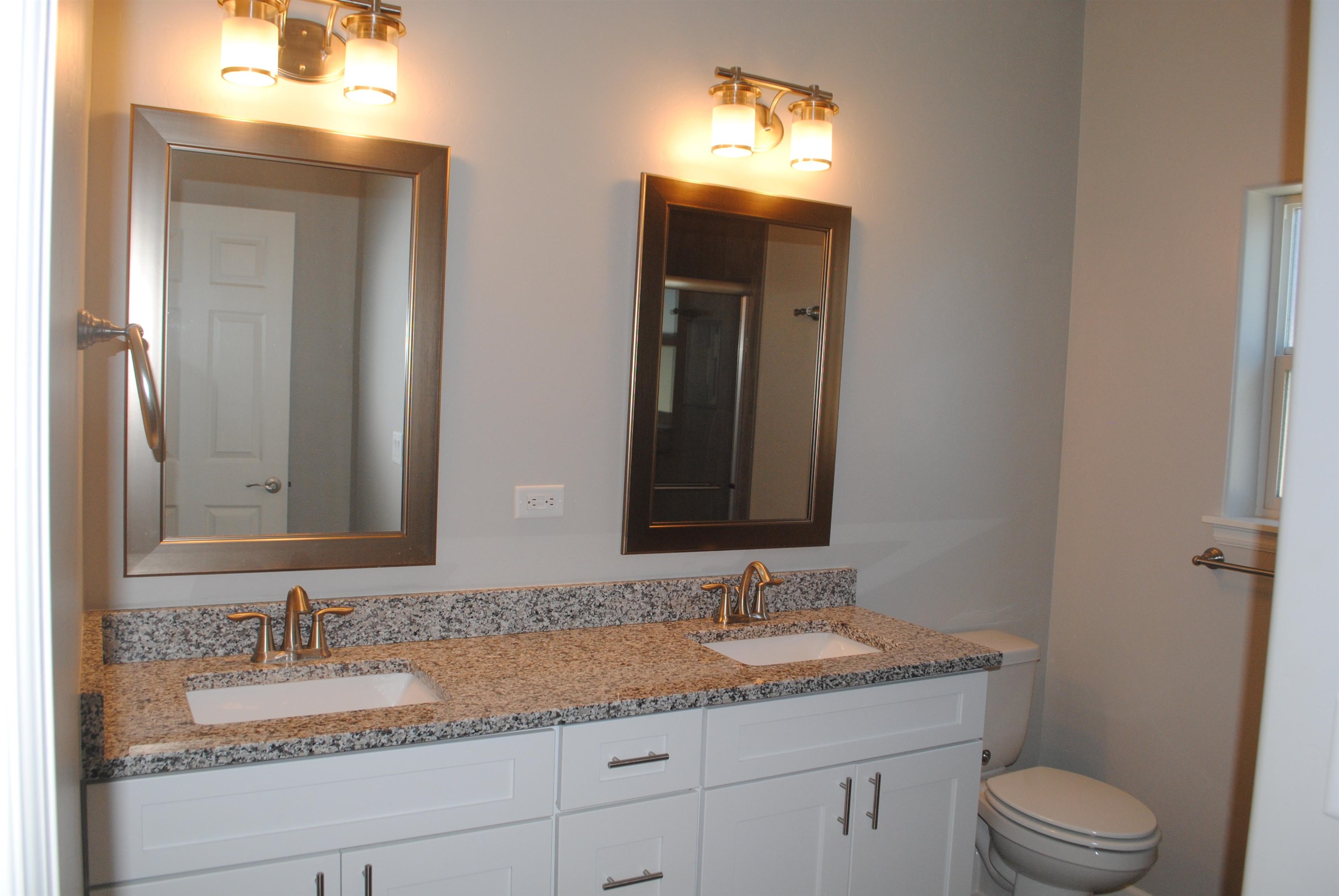 454 Lewis Street Grand Junction, CO 81504 - Photo 5 of 20 a bathroom with a granite countertop sink a toilet and a mirror