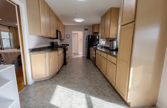 a kitchen with stainless steel appliances granite countertop a refrigerator a stove top oven a sink and dishwasher