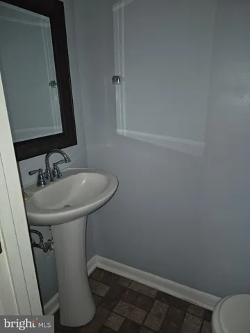 a bathroom with a sink toilet and mirror