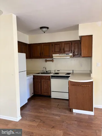 a kitchen with stainless steel appliances kitchen island granite countertop a refrigerator and a stove top oven