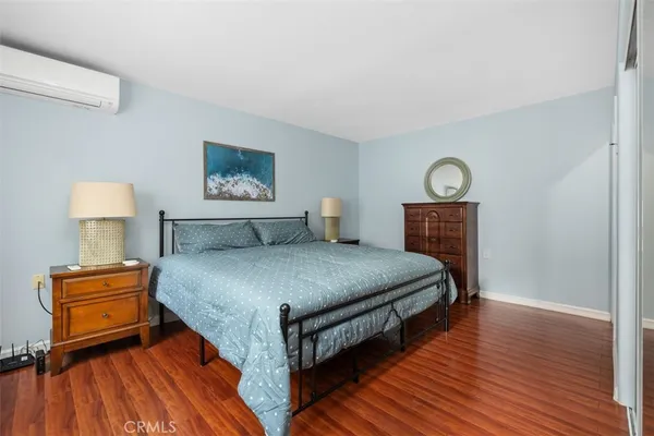 a bedroom with bed and wooden floor