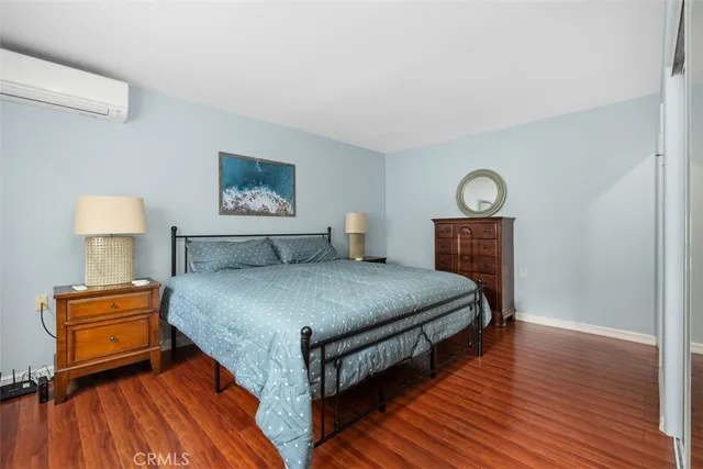 a bedroom with bed and wooden floor