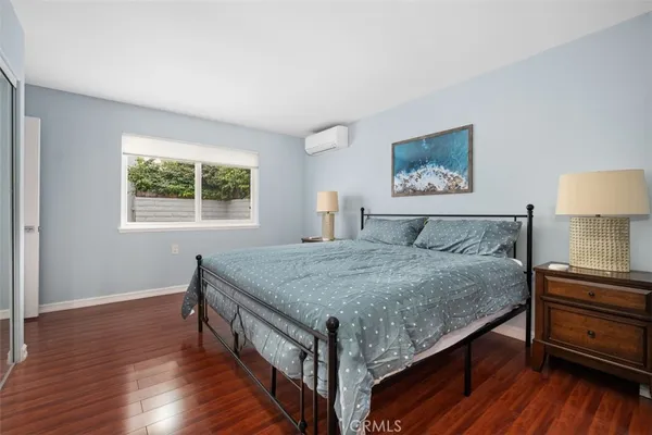 a bedroom with a bed and a dresser next to a window