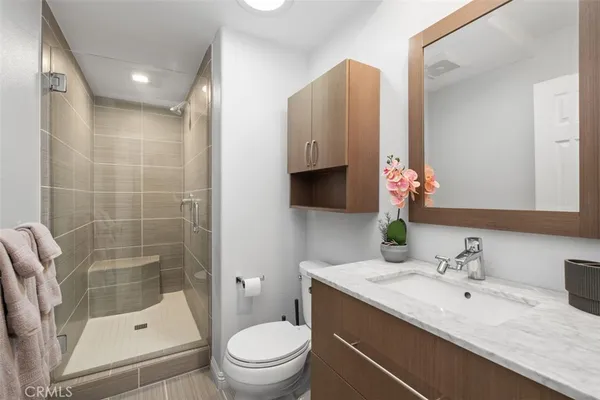 a bathroom with a granite countertop sink a toilet and shower