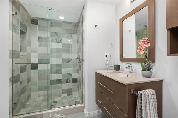a bathroom with a double vanity sink mirror and shower