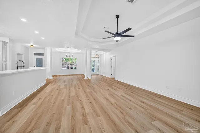a view of a living room a wooden floor and a ceiling fan