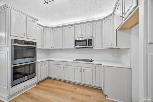 a kitchen with stainless steel appliances granite countertop a sink and dishwasher with white cabinets