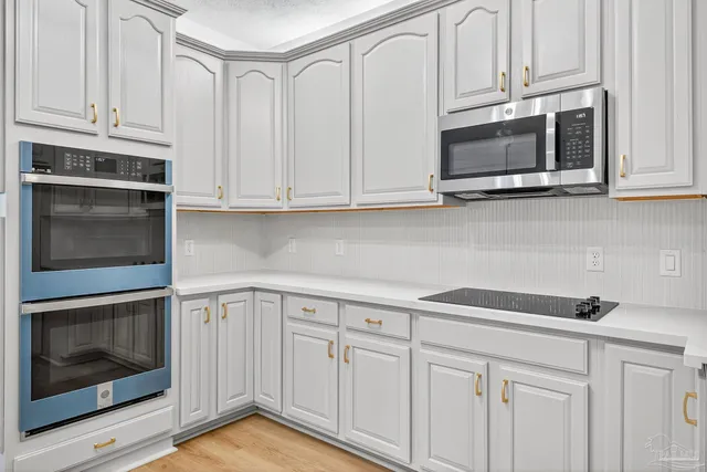 a kitchen with white cabinets and white appliances