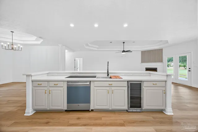 a view of a room with wooden floor kitchen view and a window