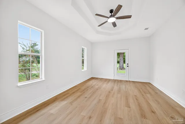 a view of empty room with wooden floor