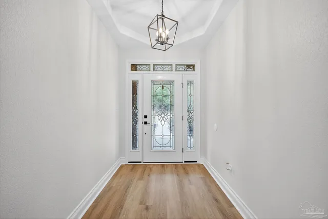 a view of empty room with wooden floor and window